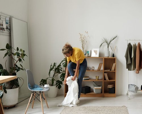 A person doing daily chores comfortably in a bright living room