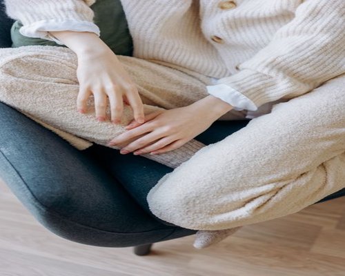 A person resting in a comfortable chair with natural light in a living room